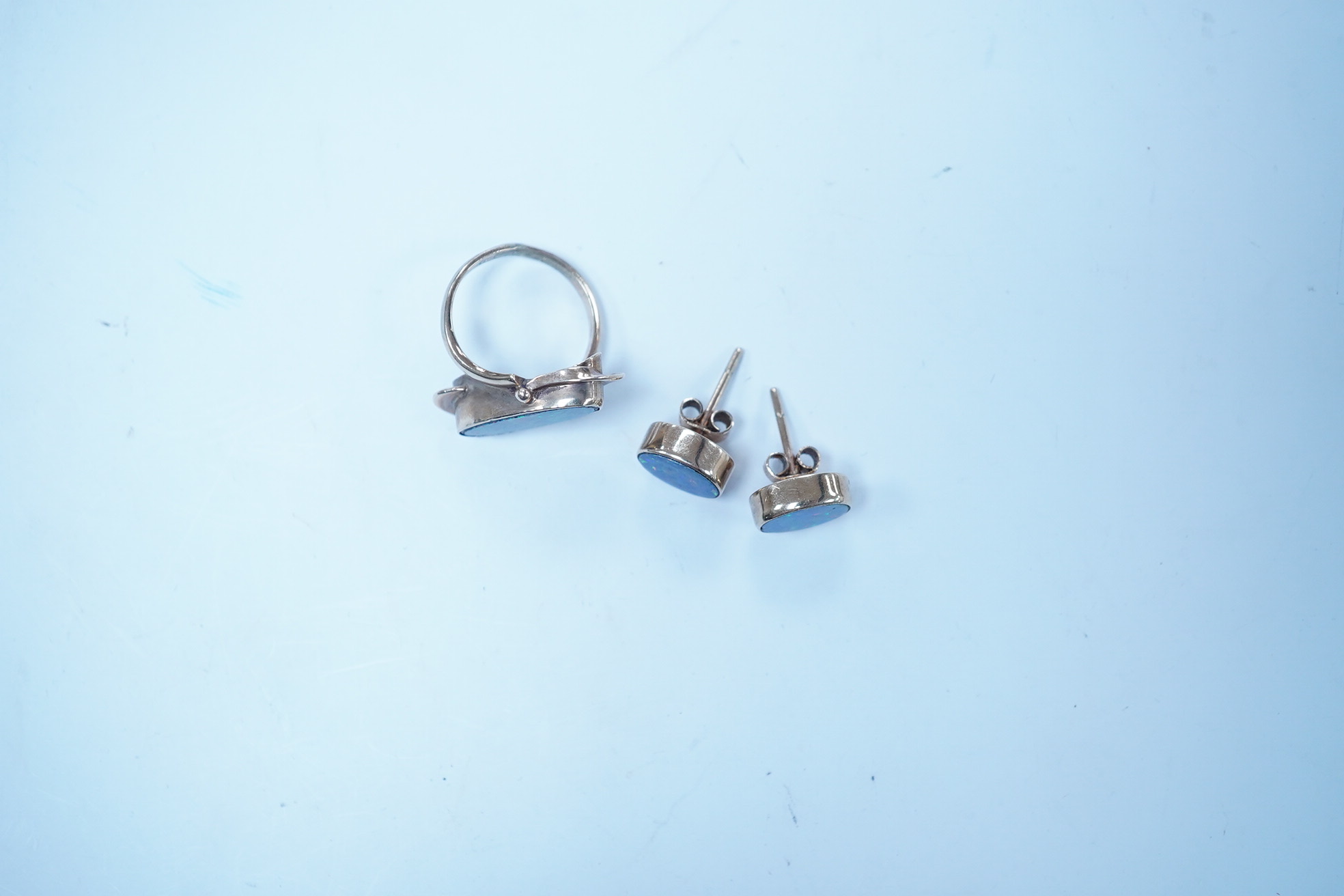 A 9ct and opal doublet ring and a pair of similar earrings, gross weight 4.8 grams. Condition - poor